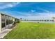 Backyard with grassy area, canal view, and screened patio at 25225 Rampart Blvd # 703, Punta Gorda, FL 33983