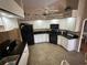 Kitchen with white cabinets, black appliances, and granite countertops at 17034 Toledo Blade Blvd, Port Charlotte, FL 33954