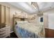 Bright bedroom featuring tray ceiling, wood floors, nautical decor, and adjacent bathroom at 17183 Carson Ave, Port Charlotte, FL 33948