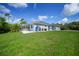 The backyard shows the home exterior including a lanai/pool area with a spacious lawn at 17183 Carson Ave, Port Charlotte, FL 33948