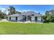 Charming home featuring blue trim accents, a well-manicured lawn and a screened in entry at 17183 Carson Ave, Port Charlotte, FL 33948