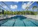 A screened-in pool with a waterfall provides a serene and inviting outdoor oasis at 17183 Carson Ave, Port Charlotte, FL 33948