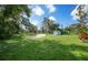 Large grassy area with mature trees and a small storage building at 17183 Carson Ave, Port Charlotte, FL 33948