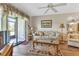 Living room with wood-look floors, sliding glass doors to patio, and a ceiling fan at 25275 Rampart Blvd # 1801, Punta Gorda, FL 33983