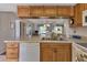 Open kitchen with wood cabinets, white appliances, and a view to the living area at 25275 Rampart Blvd # 1801, Punta Gorda, FL 33983