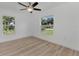 Bedroom with two windows, ceiling fan and wood flooring at 3847 E Price Blvd, North Port, FL 34288