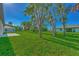 Large backyard with green grass and palm trees surrounding the home at 3847 E Price Blvd, North Port, FL 34288