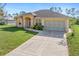 Single-story home with a two-car garage and nicely landscaped lawn at 1516 Natrona Dr, North Port, FL 34286