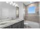 Bathroom featuring a gray vanity, modern light fixture and a tub with tile surround at 16077 Coruna Ct, Punta Gorda, FL 33955