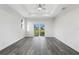 Bright bedroom with wood-look floors and a tray ceiling, complemented by natural light from sliding glass doors at 16077 Coruna Ct, Punta Gorda, FL 33955