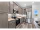 Well-equipped kitchen with stainless steel appliances, light wood cabinets, and stylish tile backsplash at 16077 Coruna Ct, Punta Gorda, FL 33955