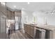 The kitchen is connected to the living room with stainless appliances, pendant lights, and wood-look floors at 16077 Coruna Ct, Punta Gorda, FL 33955