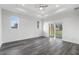 Spacious main bedroom featuring tray ceiling, fan, light gray flooring and sliding glass doors to the lanai at 16077 Coruna Ct, Punta Gorda, FL 33955