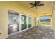 Covered outdoor patio with stylish pavers, ceiling fans, and sliding glass doors leading to an open-concept living area at 16077 Coruna Ct, Punta Gorda, FL 33955