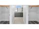 Dual walk-in closets leading to bathroom with dual sinks and grey vanity with marble countertops at 16077 Coruna Ct, Punta Gorda, FL 33955