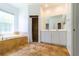 Bathroom features a large soaking tub, double vanity, and tile flooring at 1516 Natrona Dr, North Port, FL 34286
