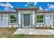 Modern front door entry with gray siding and landscaping at 4637 Corbett Ln, North Port, FL 34288