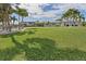 Large grassy backyard with palm trees and canal views at 374 Severin Se Rd, Port Charlotte, FL 33952
