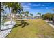Landscaped waterfront yard with palm trees and white rock at 374 Severin Se Rd, Port Charlotte, FL 33952