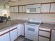 White appliances and granite countertops in this corner kitchen at 5505 Holiday Park Blvd, North Port, FL 34287
