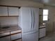 White kitchen with granite countertops and a side-by-side refrigerator at 5505 Holiday Park Blvd, North Port, FL 34287