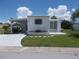 Single-wide manufactured home with carport and well-maintained lawn at 5505 Holiday Park Blvd, North Port, FL 34287