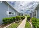 Landscaped walkway between houses with neatly trimmed hedges at 3300 Loveland Boulevard # 1904, Port Charlotte, FL 33980