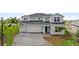Two-story home with gray siding, a three-car garage, and a paver driveway at 42548 Little Ridge Rd, Punta Gorda, FL 33982