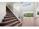 Modern staircase with brown carpet and metal railing, leading to an open living area at 42548 Little Ridge Rd, Punta Gorda, FL 33982