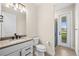 Bathroom with a single vanity, toilet, and exterior access at 42548 Little Ridge Rd, Punta Gorda, FL 33982