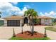 Single-story home with a large driveway, two-car garage, and mature palm trees at 5149 Latham Ter, Port Charlotte, FL 33981