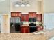 Kitchen boasts stainless steel appliances and rich wood cabinetry at 530 Kensington St, Port Charlotte, FL 33954