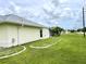 Side yard with grassy area and partial view of home at 530 Kensington St, Port Charlotte, FL 33954