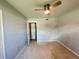 An empty bedroom boasts neutral walls, speckled floors, and a practical ceiling fan for added comfort at 1405 Dorchester St, Port Charlotte, FL 33952