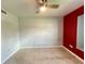This is a basic bedroom with a ceiling fan and red accent wall at 1405 Dorchester St, Port Charlotte, FL 33952