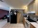 Well-lit kitchen features tile flooring, light wood cabinetry, and a black refrigerator at 1405 Dorchester St, Port Charlotte, FL 33952