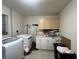A laundry room with a washer, dryer, cabinets, counter, and cleaning supplies at 1405 Dorchester St, Port Charlotte, FL 33952