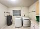 Bright laundry room with modern washer, dryer, water heater, tile flooring and ample storage space at 1405 Dorchester St, Port Charlotte, FL 33952