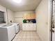 Well-lit laundry room features modern washer and dryer, ample counter space, and convenient overhead storage at 1405 Dorchester St, Port Charlotte, FL 33952