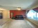 Bright living room with a dark leather sofa and a large window providing natural light at 1405 Dorchester St, Port Charlotte, FL 33952