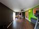 An open living room with hardwood floors, bright green accent wall, ceiling fan, and sliding doors at 1405 Dorchester St, Port Charlotte, FL 33952