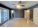 A main bedroom featuring a ceiling fan, closet, and doors to the exterior and an ensuite bathroom at 1405 Dorchester St, Port Charlotte, FL 33952