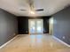 A spacious main bedroom featuring a ceiling fan and doors to the exterior with speckled terrazzo floors at 1405 Dorchester St, Port Charlotte, FL 33952