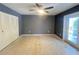 A main bedroom featuring a ceiling fan, closet, doors to the exterior and speckled terrazzo floors at 1405 Dorchester St, Port Charlotte, FL 33952