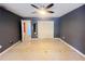 A main bedroom featuring a ceiling fan, closet, doors to the exterior and speckled terrazzo floors at 1405 Dorchester St, Port Charlotte, FL 33952