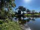 Scenic waterfront view featuring lush greenery and tranquil water reflecting the sky at 1405 Dorchester St, Port Charlotte, FL 33952