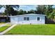 Light blue single-story house with a well-maintained lawn at 8495 Cristobal Ave, North Port, FL 34287