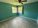 Bedroom with teal walls, wood-look tile floors, and window at 20359 Banner Ave, Port Charlotte, FL 33952