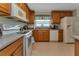 Kitchen with wood cabinets, white appliances, and gray countertops at 24496 Buckingham Way, Punta Gorda, FL 33980