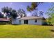 House backyard view with grassy lawn and mature trees at 20340 Zelda Ave, Port Charlotte, FL 33952